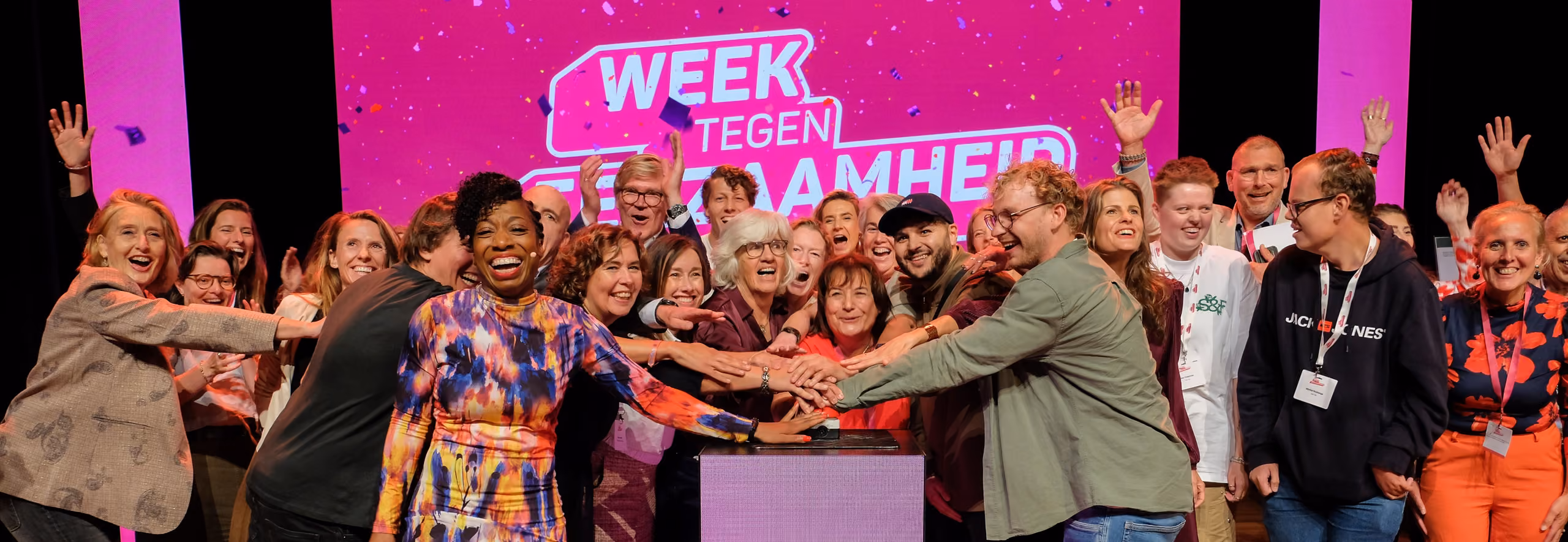 Opening Week tegen Eenzaamheid met veel mensen op podium die op een knop drukken.